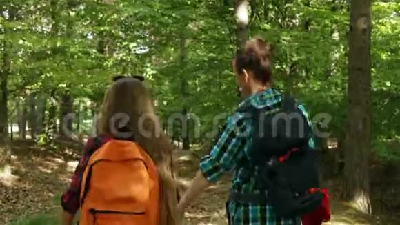 徒步旅行者在森林里走下坡路女人和少女视频的预览图