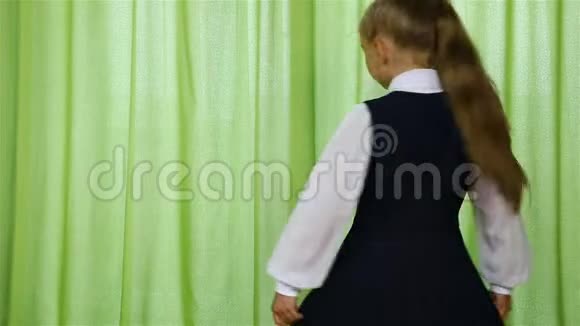 穿着校服在绿色背景下旋转的女孩视频的预览图