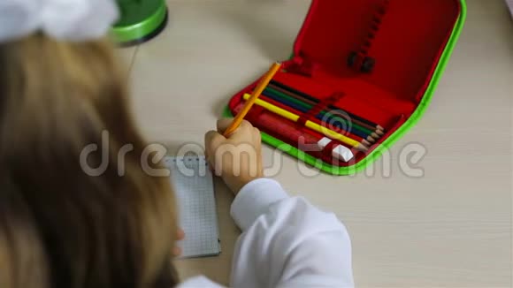 一个女孩手里拿着一支铅笔在笔记本的细胞里写信视频的预览图