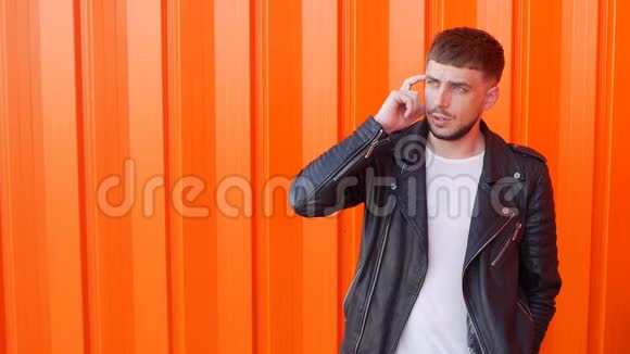 一个年轻的白种人留着胡子一张忧郁的脸站着思考橙色的背景复制的空间缓慢的声音视频的预览图