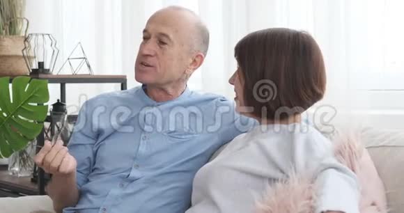 老两口坐在沙发上讨论视频的预览图