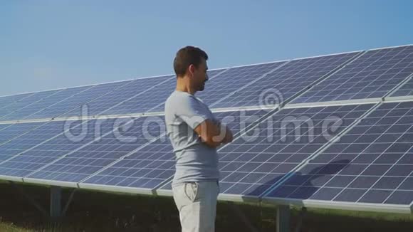 年轻人在太阳能电池板的背景上竖起大拇指视频的预览图
