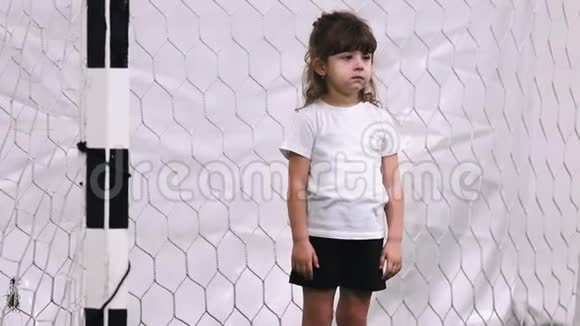 室内足球场一个小女孩守门员拥抱自己视频的预览图
