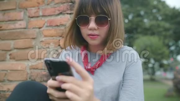 旅游亚洲妇女使用智能手机检查社交媒体同时放松后在阿育塔亚旅游泰国视频的预览图