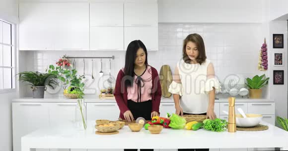 亚洲姐妹准备蔬菜和水果视频的预览图