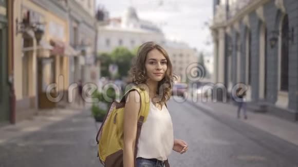 迷人的女人的肖像微笑黑发自信漂亮在欧洲小街上关闭慢动作视频的预览图