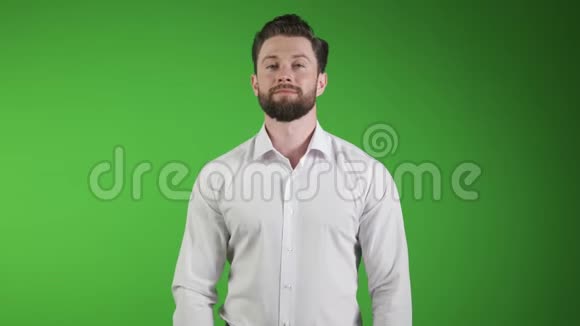 可爱的帅哥穿着休闲装双臂交叉微笑站在绿色隔离的英俊青年视频的预览图