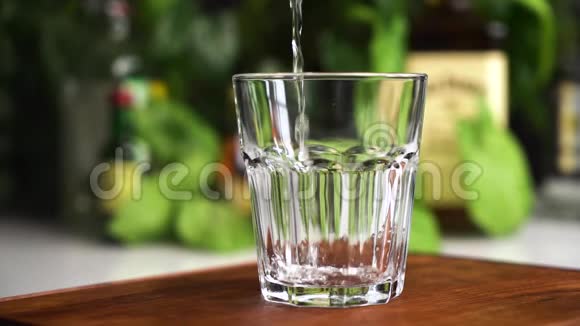 慢动作矿泉水或苏打水在玻璃杯中加入石灰薄荷和冰块食物背景视频的预览图