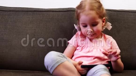 一个小女孩在玩智能手机不想用勺子吃饭视频的预览图