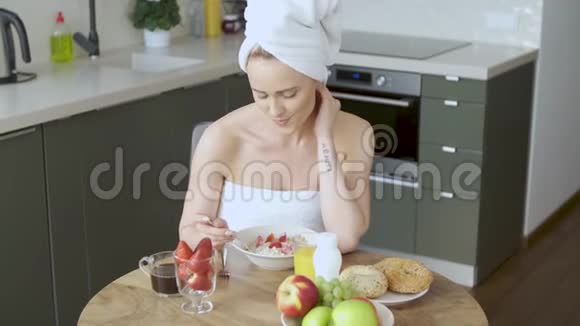 早晨美丽的中年妇女坐在厨房里视频的预览图