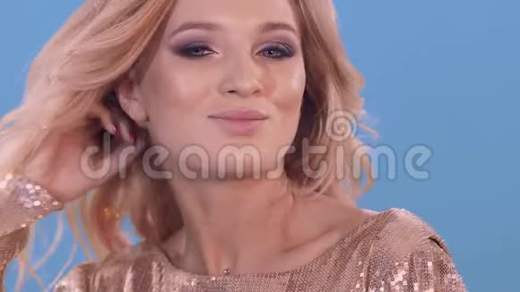 美丽的时尚肖像蓝墙背景上微笑的年轻女人视频的预览图