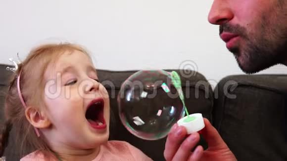 一个小女孩一个尝试抓住肥皂泡在她的嘴和微笑视频的预览图