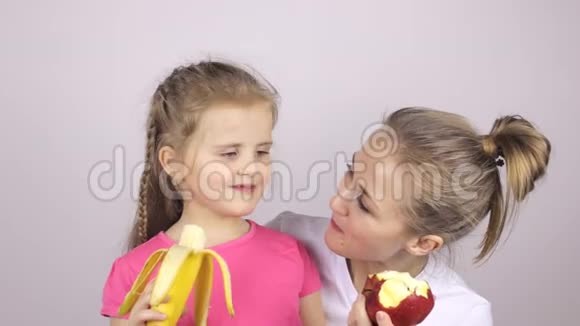 美丽的女儿和母亲吃水果微笑着视频的预览图