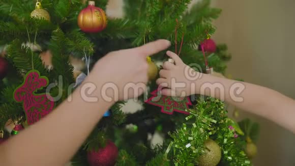 母亲和孩子在家里一起装饰圣诞树视频的预览图