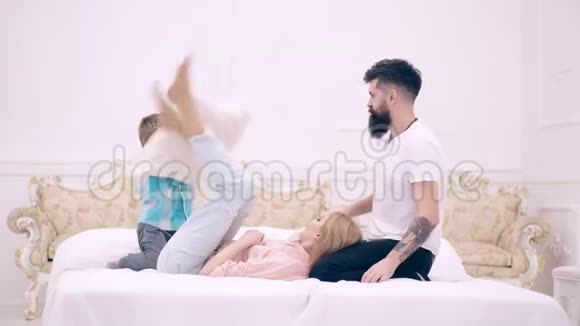 一家人在床上玩枕头大战父母和儿子一起度过空闲时间一家人都很开心视频的预览图