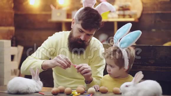 复活节快乐一位父亲和他的儿子画了复活节彩蛋为复活节做准备的幸福家庭可爱的小男孩视频的预览图