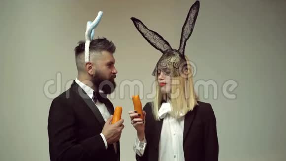 快乐有趣的复活节夫妇与胡萝卜家人庆祝复活节复活节兔子一对有兔子耳朵的有趣的复活节视频的预览图