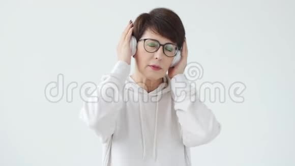 爱好兴趣和人的概念4050岁的美女听大耳机音乐视频的预览图