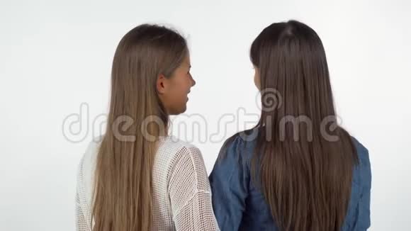 后景拍摄两位女性朋友肩膀上对着镜头微笑视频的预览图