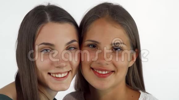 两个年轻漂亮的女朋友对着镜头微笑脸颊贴着脸视频的预览图