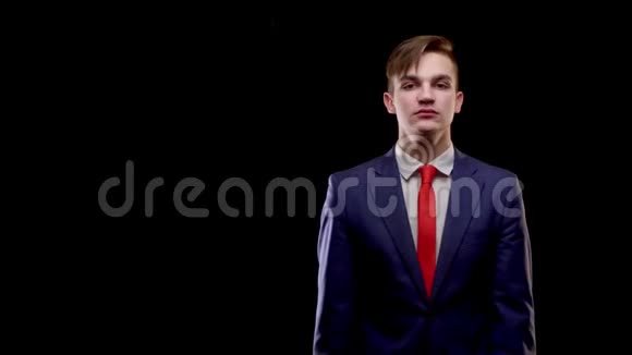 一个白人年轻人穿着一套简单的蓝色西装在混乱中系着一条红色领带抓住了他的头视频的预览图