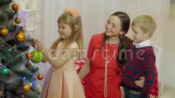 小女孩装饰他们的圣诞树视频的预览图