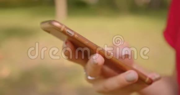 在公园户外使用电话的年轻白种人女性手的特写照片视频的预览图