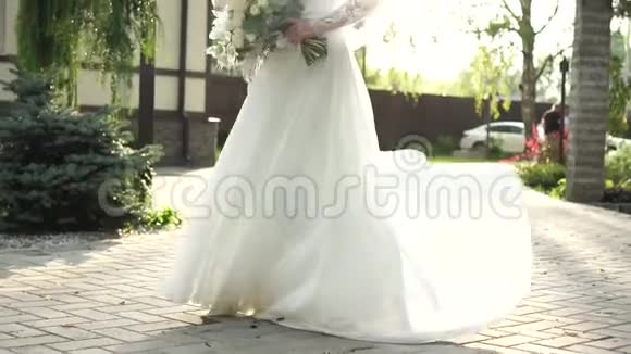 一位美丽的新娘在阳光下穿着裙子盘旋的肖像视频的预览图
