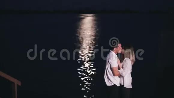 晚上在河边接吻的年轻人和美女月光视频的预览图