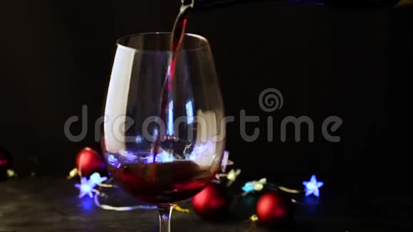 在黑暗的节日背景上用酒杯斟上红酒酒色缤纷视频的预览图