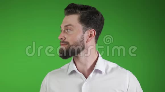 戴着白色耳机听音乐的帅哥站在绿色的墙壁背景下视频的预览图