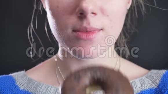 特写的女孩咬和咀嚼美味的釉棕色甜甜圈与巧克力片在黑色背景视频的预览图