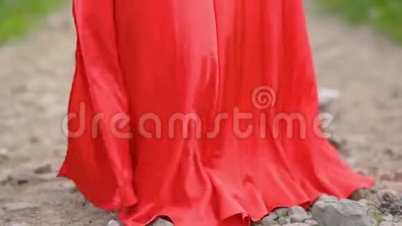 穿着红色裙子的女孩穿着这件衣服沿着森林小径奔跑视频的预览图