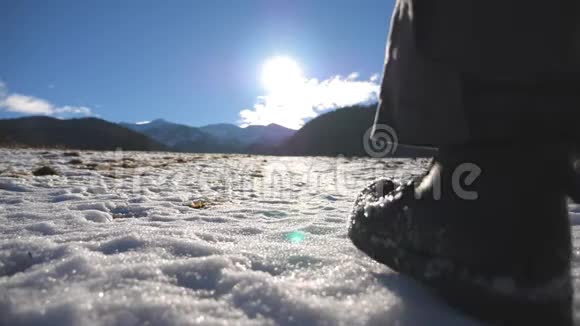 在阳光明媚的日子里一个不可辨认的家伙用棍子爬上了草地上的雪山年轻徒步旅行者徒步旅行视频的预览图