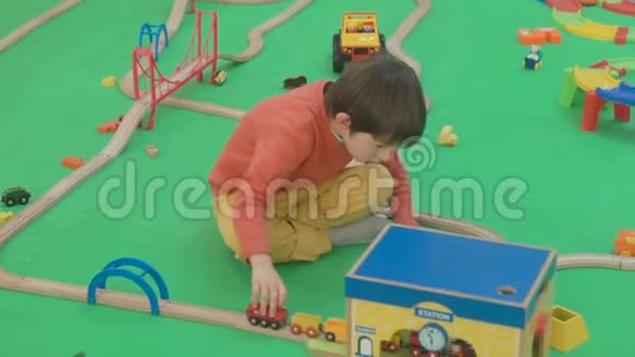 5岁的男孩在孩子们的房间里玩木铁路地板视频的预览图