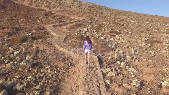女孩爬上山坡视频的预览图