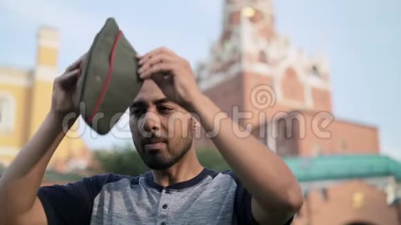 快乐的西班牙裔游客在克里姆林宫附近戴上俄罗斯军帽视频的预览图