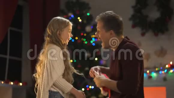 快乐的爸爸和女儿在圣诞前夜玩得开心享受着神奇的气氛视频的预览图