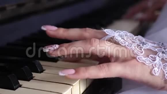 戴着白手套的女孩用漂亮的指甲弹钢琴播放音符上的旋律音乐视频的预览图