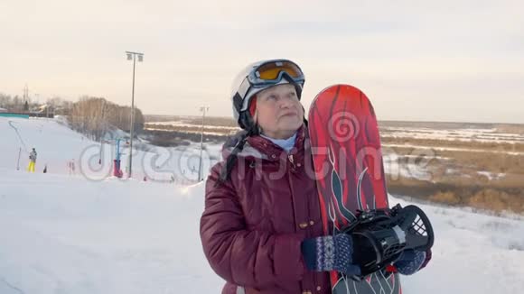 有滑雪板的老年妇女站在滑雪场的冬季自然背景下视频的预览图