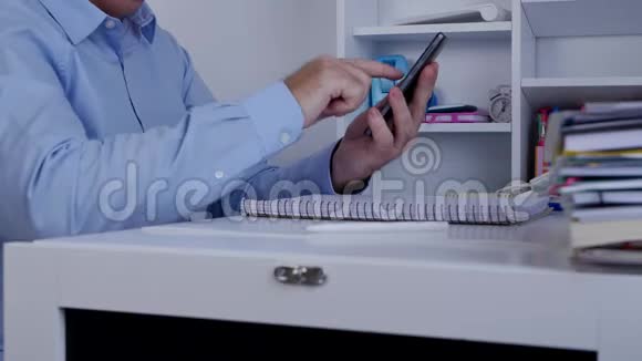 室内办公室用手机触屏拍摄商人短信视频的预览图