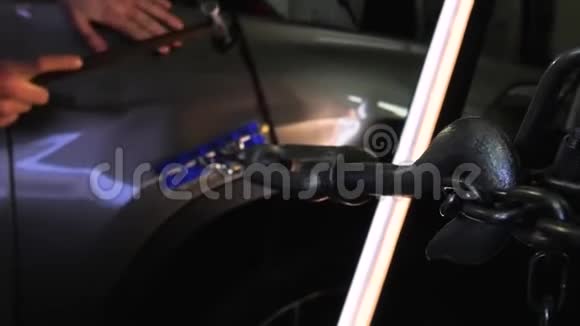 PDR油漆凹痕修复拆除一个人用钢锤敲着一辆汽车使凹痕平整特写金属钥匙视频的预览图