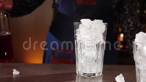 酒保双手同时在冰块上倒入两种鸡尾酒配料视频的预览图