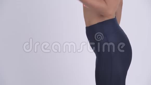 年轻金发女子用哑铃锻炼的侧影视频的预览图