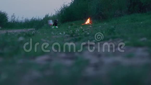 在河边绿草丛生的岸边烧篝火视频的预览图
