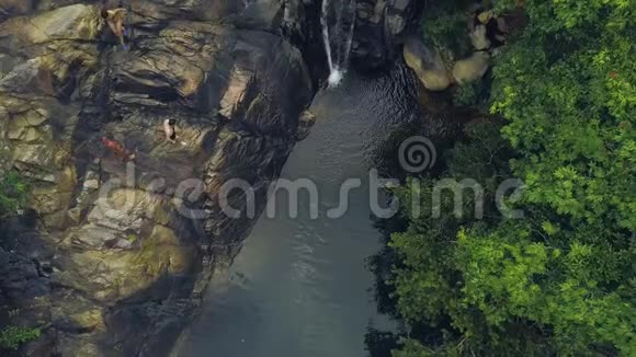 游客在热带雨林空中景观中的高山瀑布中潜水和游泳人们在河水中跳跃视频的预览图