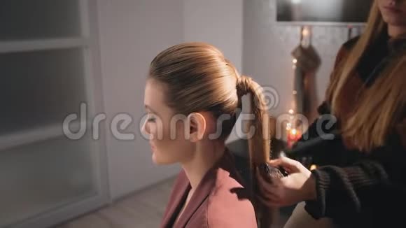 美容师化妆师发型白人模特金发它分散清漆使头发整洁使用视频的预览图