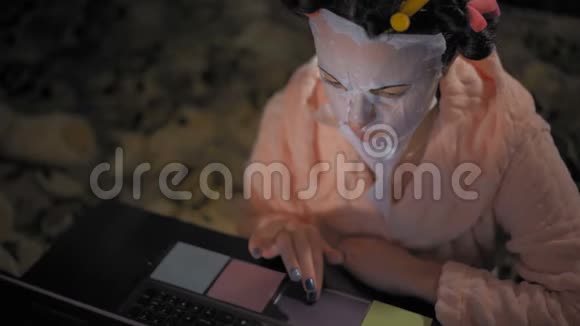特写镜头粉色罗贝中的女人在笔记本电脑上重新焕发青春的面具视频的预览图