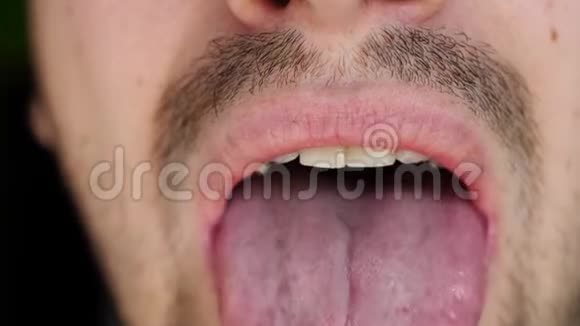 人把白色药丸放进嘴里舌头上堆积着白色的药物关门视频的预览图