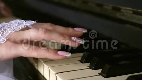 戴着白手套的女孩用漂亮的指甲弹钢琴播放音符上的旋律音乐业务视频的预览图